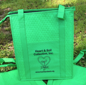Bright green reusable bag with the logo and text "Heart & Soil Collective, Inc." along with their website, www.heartandsoil.org, displayed on the front.