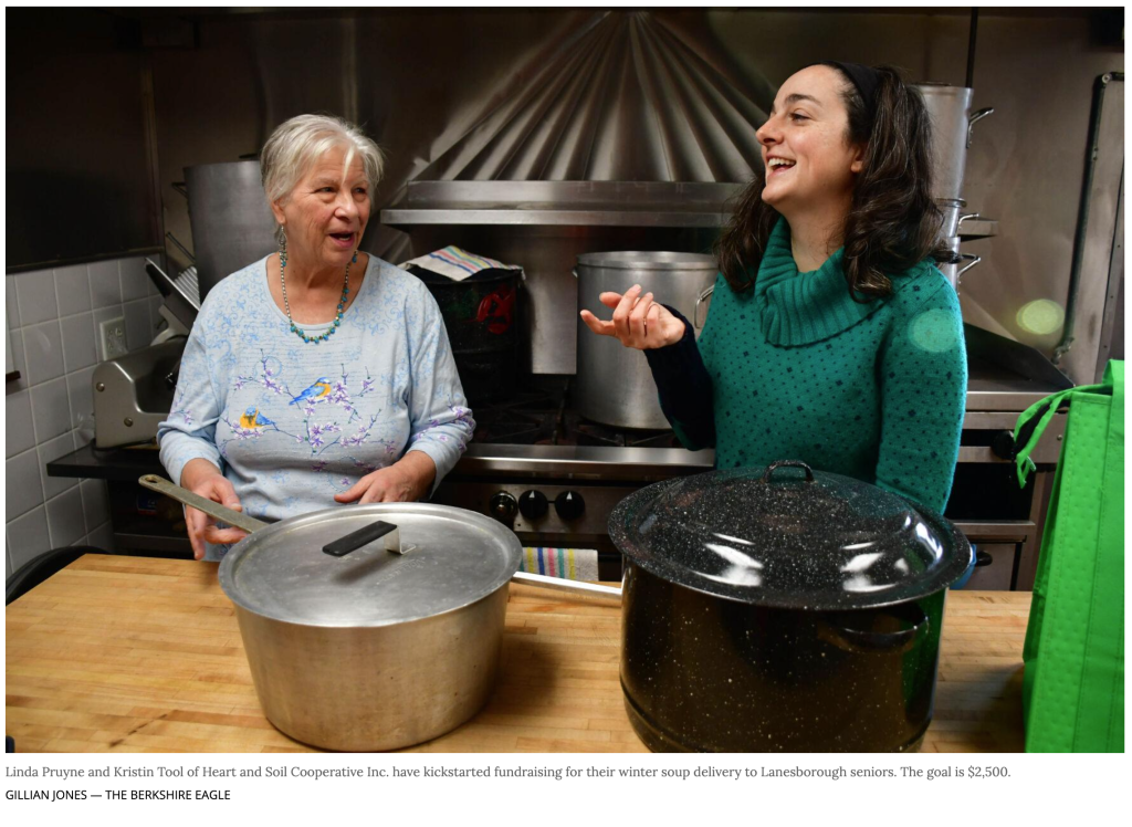 Kristen Tool and Linda Pruyne talk in a kitchen while preparing large pots of soup for a fundraising effort to support winter soup delivery for seniors.