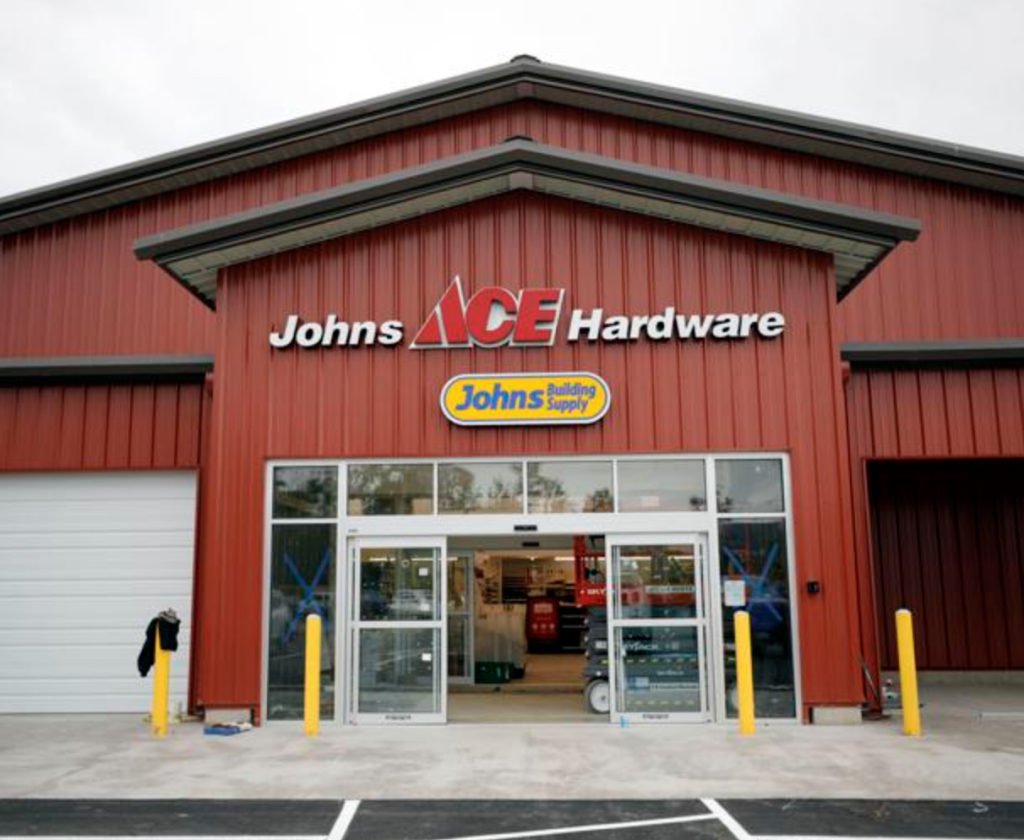 Photo of the exterior of Johns ACE Hardware and Johns Building Supply, a red building with signage above the entrance.